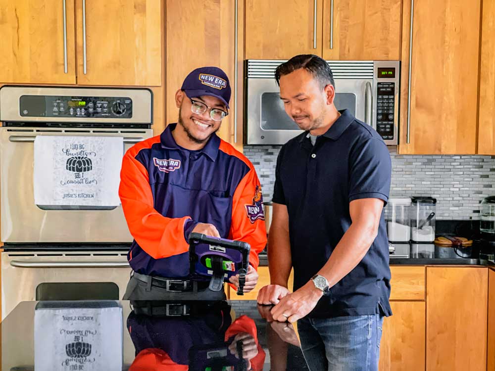 A New Era team member talks to a client in a kitchen