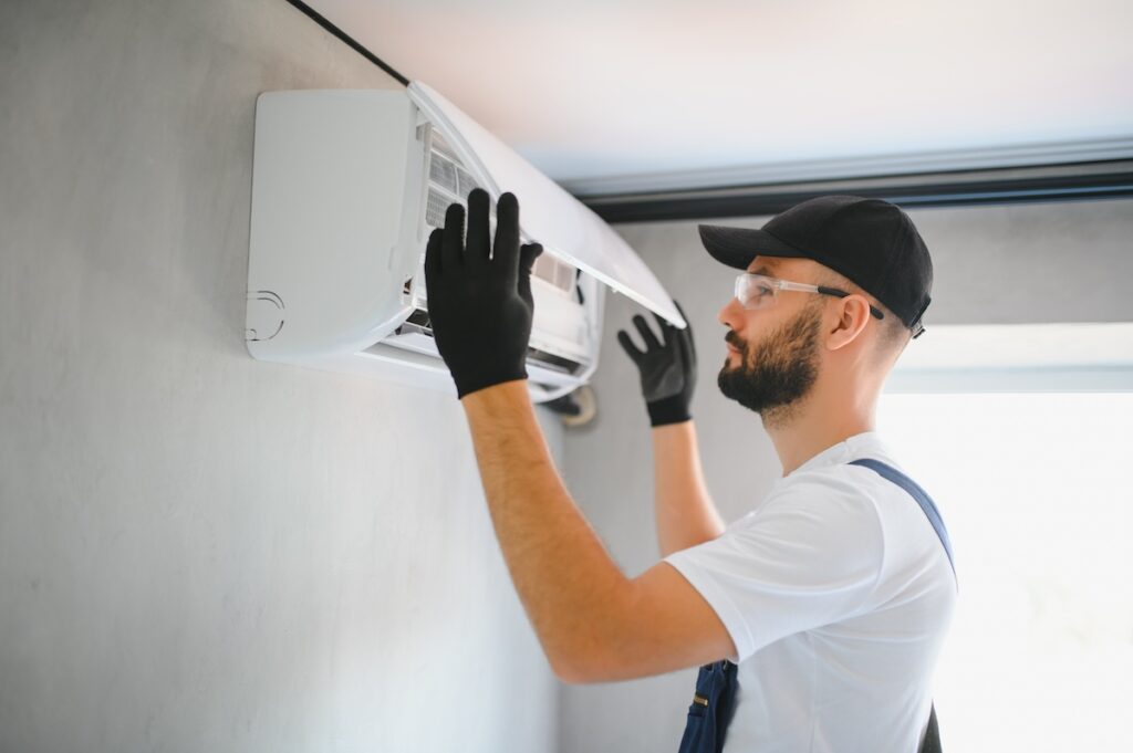 Repairman fix air conditioning systems, Male technicians service for repair and maintenance of air conditioners, Air conditioning technicians install new air conditioners in homes.