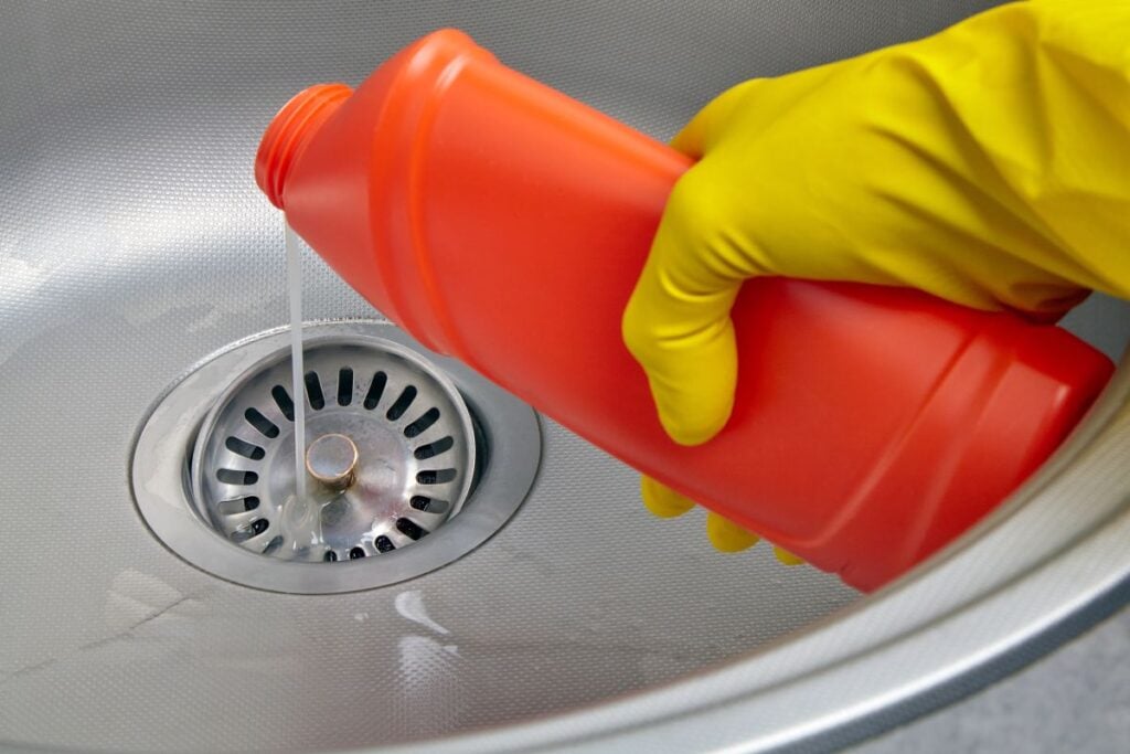 drain cleaning yellow glove using cleanser