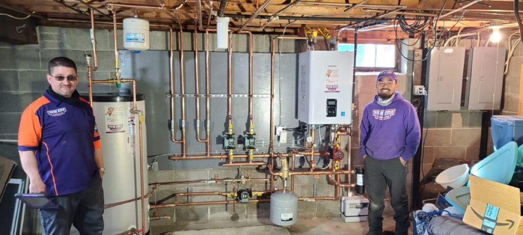 how to unclog ac drain line two workers posing New Era Plumbing