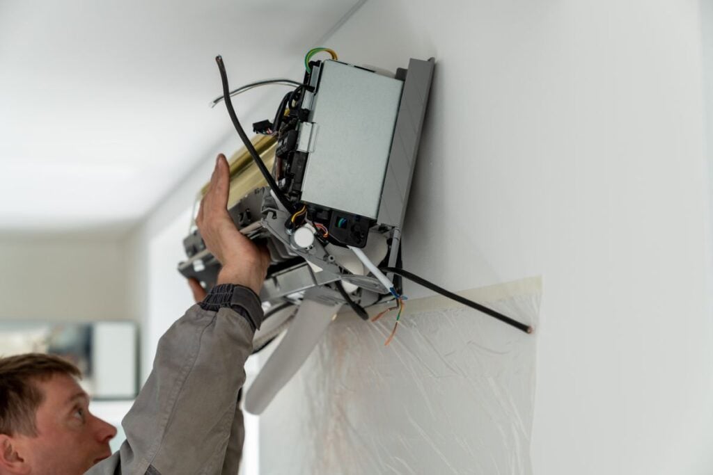 mini split vs central air man's hand installing ac unit