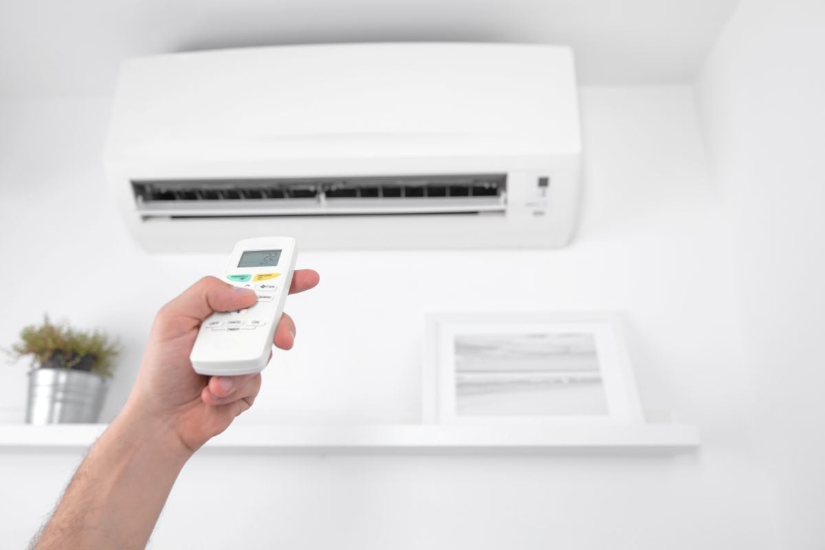 Man holding a modern AC unit remote