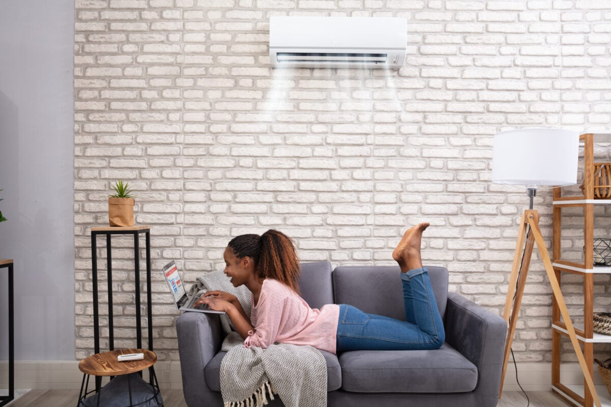 mini split heat pump woman enyoing air conditioner on sofa