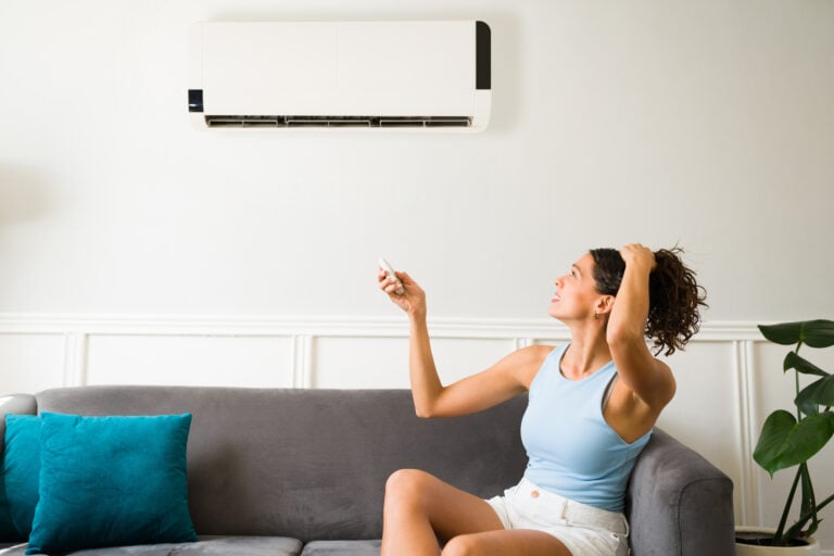 ac blowing warm air Hot young woman feeling sweaty during a heat wave because her air conditioning is not working