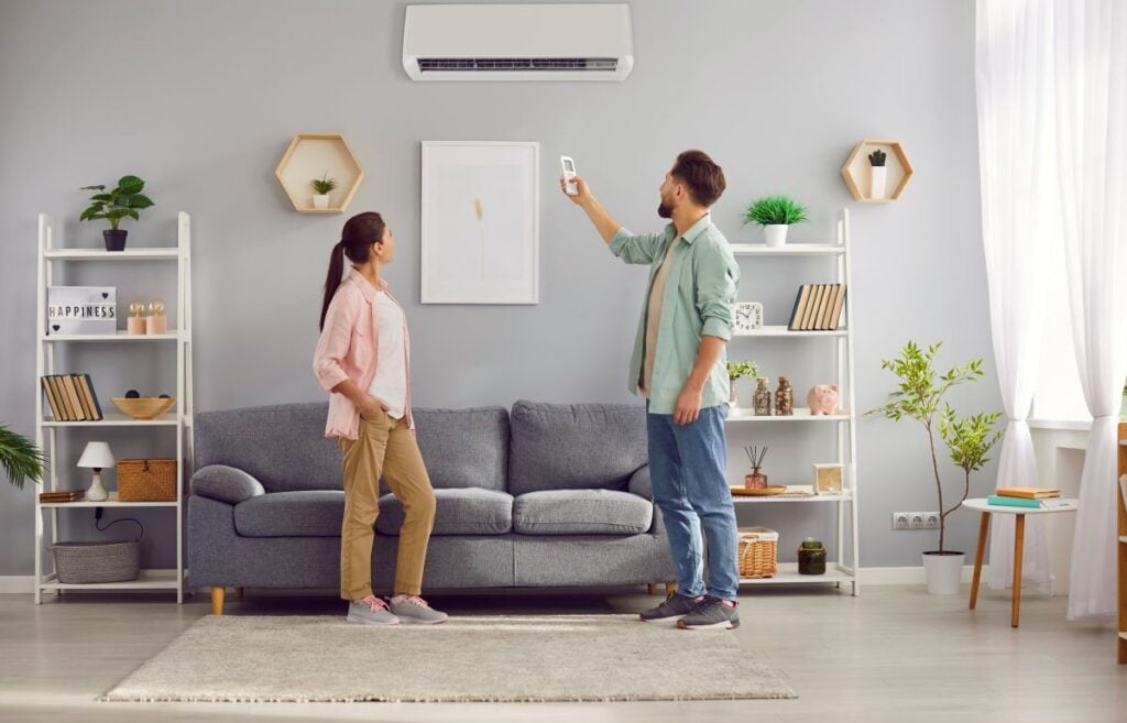emergency ac repair man and woman standing in front of ac