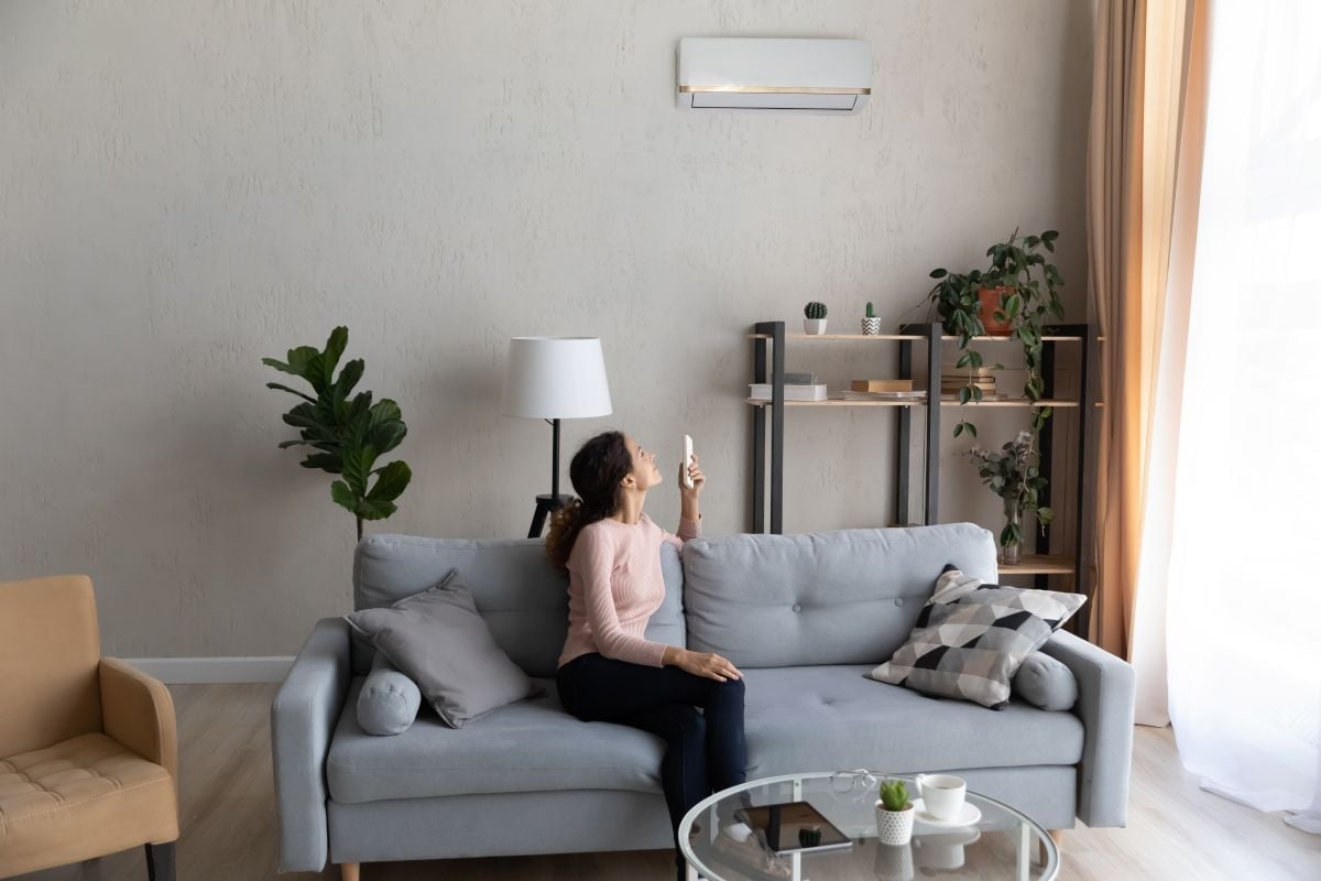 ductless air conditioner woman turning on ac unit