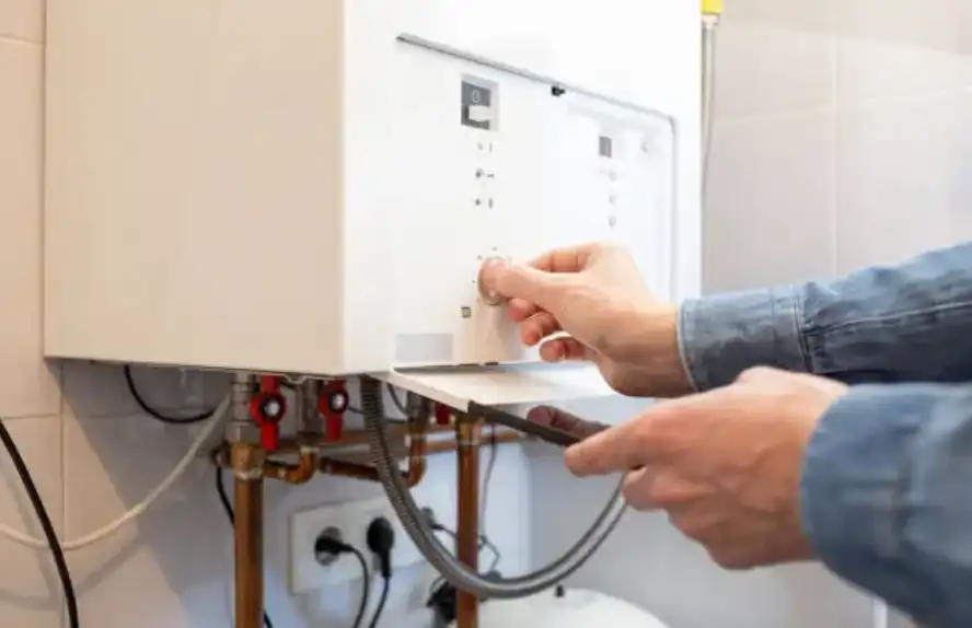 Person adjusting temperature settings on a home boiler.